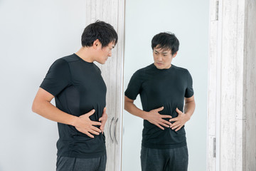 鏡の前でボディチェックする男性