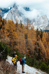 Team of travellers have a break while hiking the ''lago di sorapis'' trail in Italian alps /  Dolomite mountains in background during sunset / High ISO image