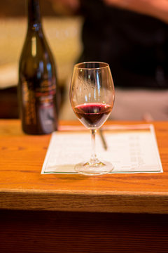 close up of a glass of red wine and a bottle of wine at a wine tasting event in Napa Valley