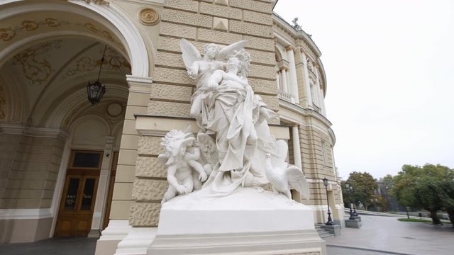 Sweeping move past dramatic statue with angelic woman over pleading man 4K