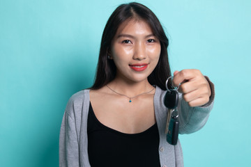 Cute asian girl showing home residence keys.
