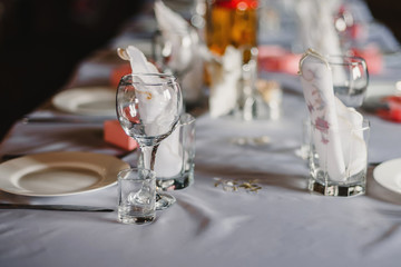 set of empty glasses and plates with Cutlery on a white tablecloth on the table in the restaurant