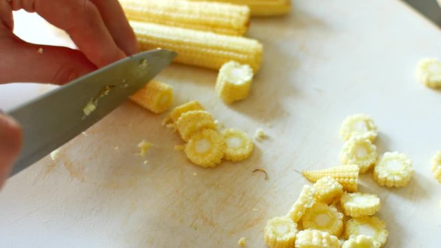 Cooking in the kitchen, slicing baby corn