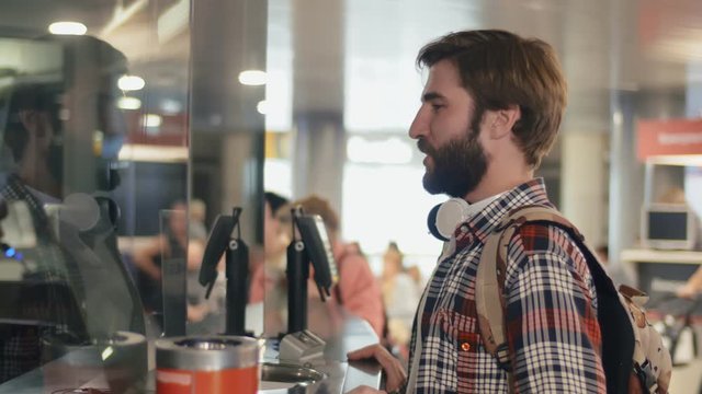 Male tourist buying train tickets at the train station