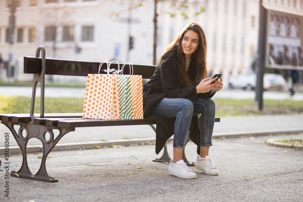 Sticker Beautiful woman siting on a bench and typing a message