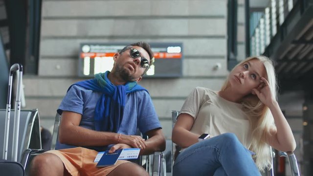Young couple waiting to board their flight in airport terminal