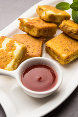 Amritsari Paneer Tikka made using cottage cheese cubes dipped in a batter made with besan, chat masala and spices and shallow fried in pan, served with ketchup