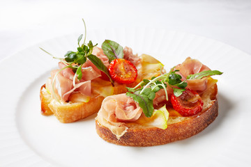Fototapeta na wymiar sandwiches with ham, baked tomatoes, cheese, herbs and spices