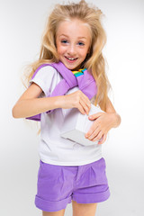 Sports teenager girl in sport suit holds a tablet with keyboard isolated on background