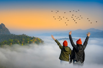 couple lover are enjoy the nature life of travel on the peak of mountain with full around of the nature mist on the hills, cheerfully life of the nature surrounding © ID_Anuphon