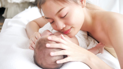 Obraz na płótnie Canvas Happy mother hug sleeping baby in the room.