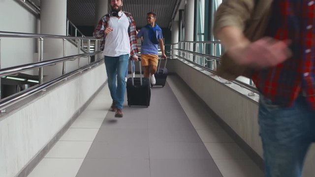 Anxious four young friends hurrying at airport trying not to miss plane