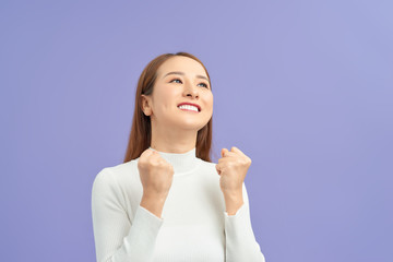 Young woman over isolated violet wall celebrating a victory