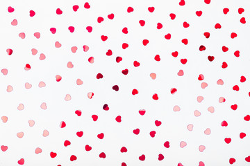 Grey background with red glitter heart confetti. Valentine day concept. Trendy minimalistic flat...