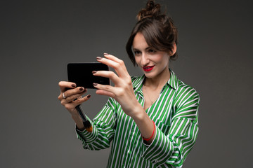 girl with red lipstick on her lips makes selfie on a dark background