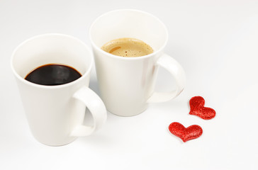 Two white mug of coffee and with two red glitter hearts  on white background  , Valentine's day concept.