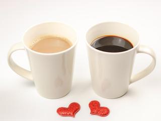 Two white mug of coffee and with two red glitter hearts  on white background  , Valentine's day concept.
