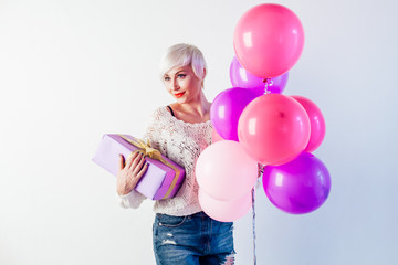 beautiful blonde with balloons and gifts on the holiday
