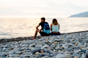 Young white guy and girl on the beach. Focus in the foreground