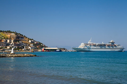 The marina in Kusadasi. The coast and port in the city, fishing boats and tourist ship. Place of holiday photos.