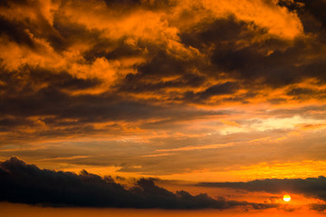 Fototapeta na wymiar Orange dramatic cartoon cumulus clouds at sunset