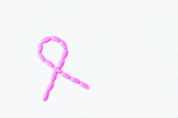 Pink ribbon symbol from the pills (tablets) on a white background. Symbol of breast cancer...