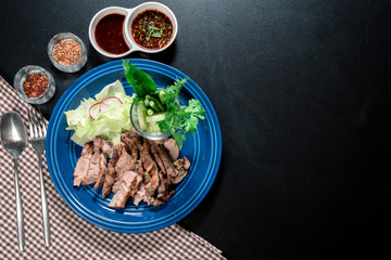 Traditional Thai food, Sliced grilled beef and organic vegetable salad with chili sauce thai style dressing on wooden plate have an appetizer dining in restaurant.