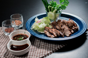 Traditional Thai food, Sliced grilled beef and organic vegetable salad with chili sauce thai style dressing on wooden plate have an appetizer dining in restaurant.