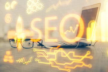 Multi exposure of table with computer and seo drawing hologram. Search optimization concept.