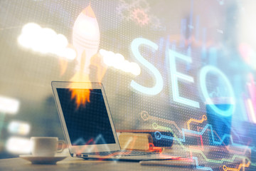 Multi exposure of table with computer and seo drawing hologram. Search optimization concept.