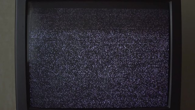 broken small black and white old TV-set flashes with rippling screen in room extreme close view