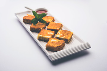 Amritsari Paneer Tikka made using cottage cheese cubes dipped in a batter made with besan, chat masala and spices and shallow fried in pan, served with ketchup