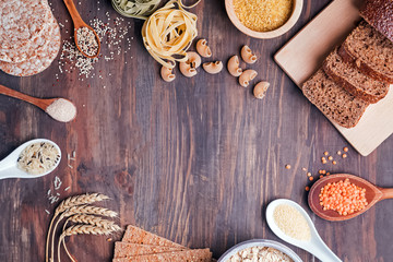 Flour, bread, dry pasta and lentils and other ingredients on the wooden table.