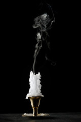 smoke over an extinguished candle with smudges of wax