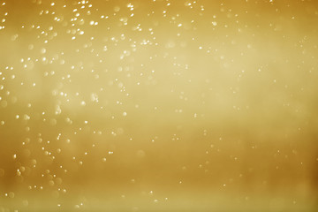 Abstract bokeh light sparkle on gold background