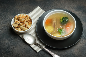 Hearty lunch. Meat broth or bouillon  from veal with breadcrumbs on a dark background.
