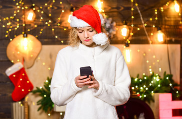 Best time together. share good news with family. happy new year. chatting with friends. woman write sms on phone. woman in santa hat. xmas interior. christmas greetings