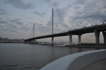 Beautiful evening view of a gray bridge over a river and grey sky