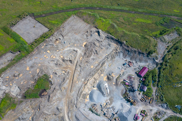 Aerial view of a small plant for the production and cleaning rubble and cement near the heaps of building materials, the tractors and trucks transports the finished product. Mining in quarry.