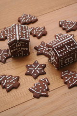 Christmas background. Homemade Christmas chocolate cookies in shape of little houses and trees on a wooden table