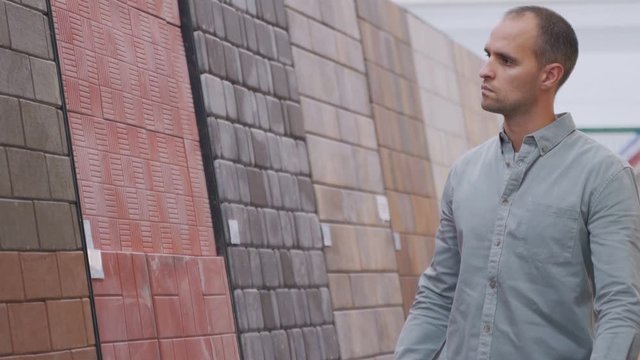 Man chooses paving slabs in the store