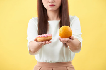 Woman holding orange and donut cake.