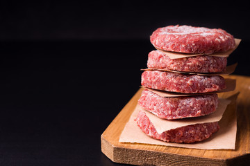 frozen raw minced meat in the form of cutlets on a black background. have copy space
