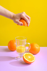 Female hand holding crushes orange and juice.