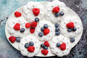 White meringues cakes with berries, raspberry and blueberry. Flat lay, top view