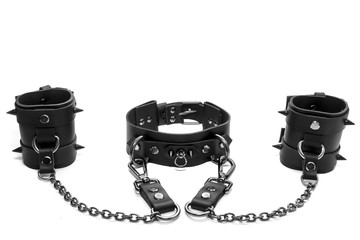 Black BDSM collar with spikes and leather bracelets on his hands - obrazy, fototapety, plakaty
