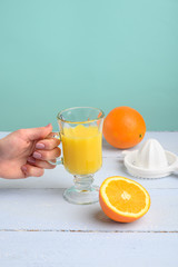 Oranges, a transparent glass and a juicer.Summer mood and vitamins.