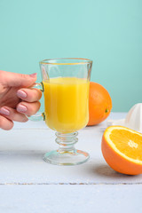 Oranges, a transparent glass and a juicer.Summer mood and vitamins.