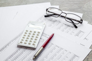 Taxes calculation concept. Financial documents, calculator, glasses on grey background