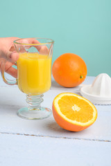 Oranges, a transparent glass and a juicer.Summer mood and vitamins.